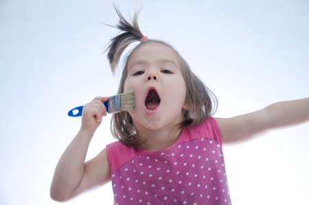 child singing song emotionally with paint brush. Artist  imaginingの写真素材