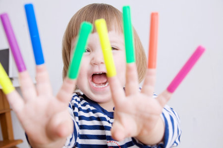 child happy smiling sitting on floor playing with felt tip pens. baby girl painting and playing....