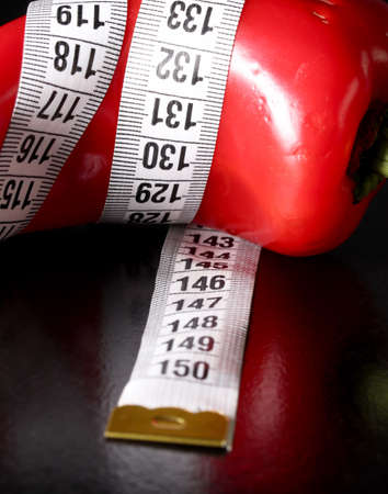 colored measuring tape colored red bell on black backgroundの写真素材