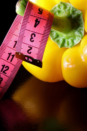 bell pepper and measuring tape on a black background