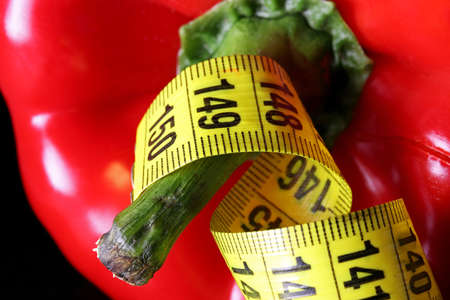 colored measuring tape colored red bell on black backgroundの写真素材