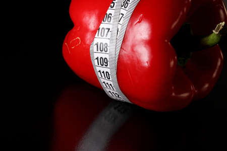 colored measuring tape colored red bell on black backgroundの写真素材