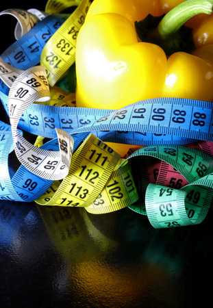 colored measuring tape colored red bell on black background