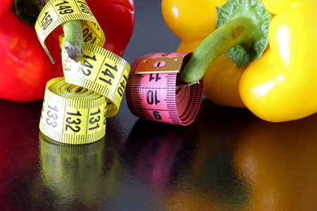 colored measuring tape colored red bell on black backgroundの写真素材