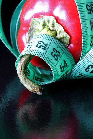 colored measuring tape colored red bell on black backgroundの写真素材