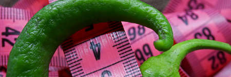 close-up concept with measuring tape and green pepperの写真素材