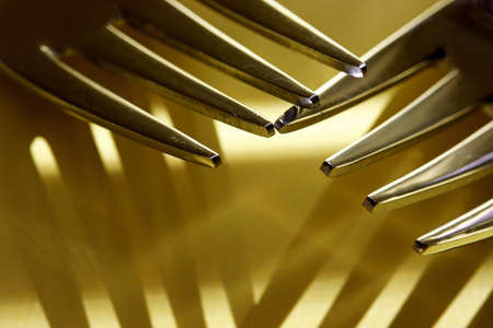 close-up metal fork with shadows on yellow backgroundの写真素材