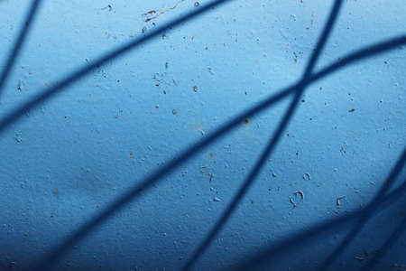 oblique shadows on blue metal surfaceの写真素材