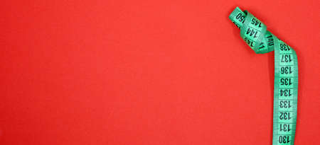 green tape measure on red backgroundの写真素材