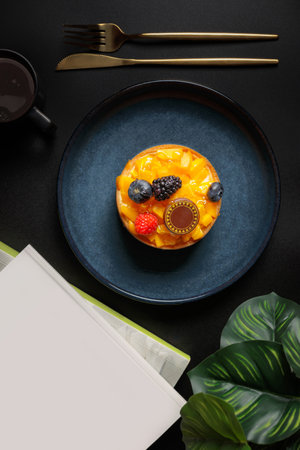 Delicious cake with fruits on plate, on black table, top viewの写真素材