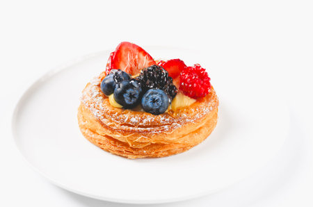 Delicious puff pastry with berries on white plate isolated on white background