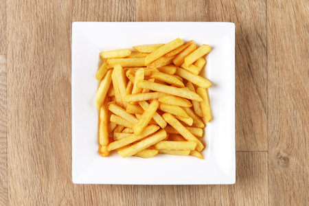 French fries - white plate square - wooden background