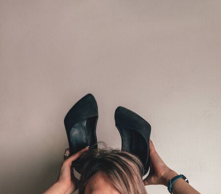 The blonde holds on her head shoes like ears of the Easter Bunnyの写真素材