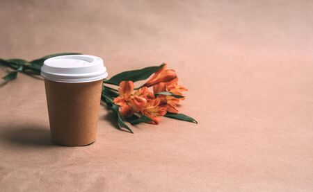 Cup of coffee and alstromeria on a craft backgroundの写真素材