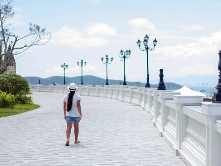 A girl walks along the embankment. Rear viewの写真素材