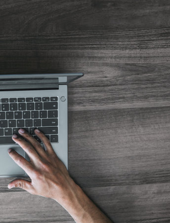 Mens hands in black electronic watches on the keyboard of a laptop against the background of a...
