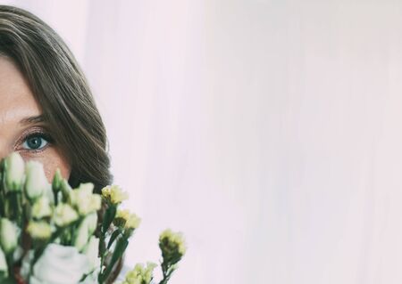 Portrait of a young woman in flowers. Womans face with make-up and hairstyleの写真素材