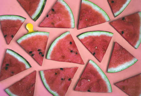 Pattern of watermelon slices on an ice cream stick on a pink background. Creative idea top viewの写真素材