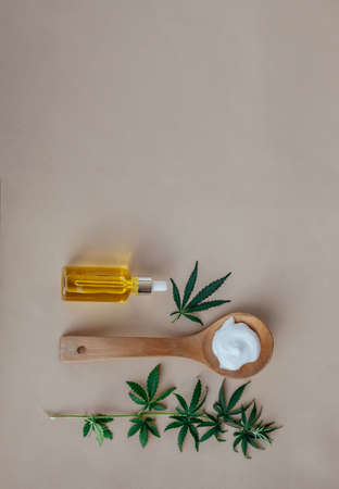 Glass bottle and dropper CBD OIL, THC tincture and cannabis leafs on pastel background. Laboratory Production of cosmetics with CBD oil. Top viewの写真素材