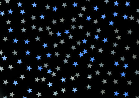 Blue and silver stars glitter on a black isolated background. Festive holiday backdrop.の写真素材