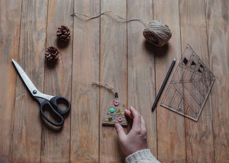 A woman holds a handmade Christmas tree toy in her hand. Concept of xmas diy. Top viewの写真素材