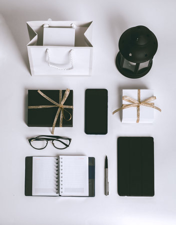 Gifts, black and golden decorations on white background. Copy space. workspace, door-to-door...