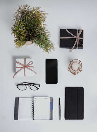 Christmas business composition. Gifts, black and golden decorations on white background. Christmas, winter, new year concept. Copy space. workspace, door-to-door delivery, Pine branchesの写真素材