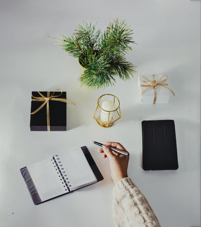 Holiday decorations and notebook with wish list on white table, flat lay style. Planning concept....
