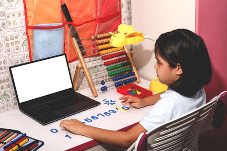 Asian schoolgirl studying homework math during her online lesson at home, video call zoom with laptop at home. New normal.Covid-19 coronavirus. Social distancing. Stay homeの写真素材