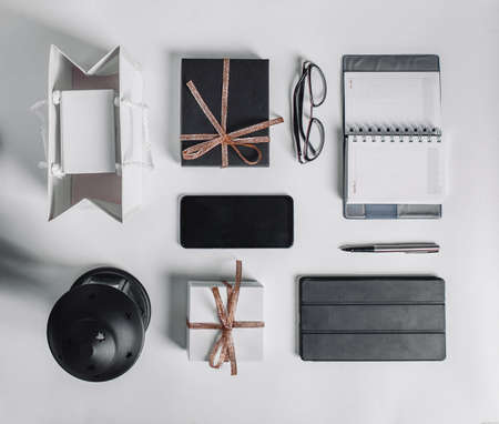 Gifts, black and golden decorations on white background. Copy space. workspace, door-to-door delivery, Christmas or Valentines day concept, corporate birthday party, mothers and womens day.の写真素材