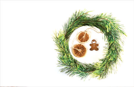 Christmas composition. Cookies in the form of a man in a mask. Holiday concept in the context of the coronavirus pandemic. Pine branches around a white plate. Bannerの写真素材