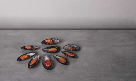 Seafood. The delicious, cooked mussels on a grey stone background. Minimalism in food photographyの写真素材