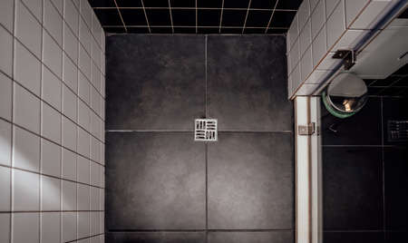 Floor drain, running water in shower, White and black tilesの写真素材
