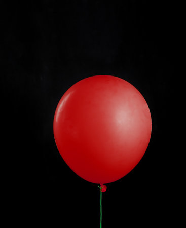Beautiful red balloon on black isolated background. Layoutの写真素材