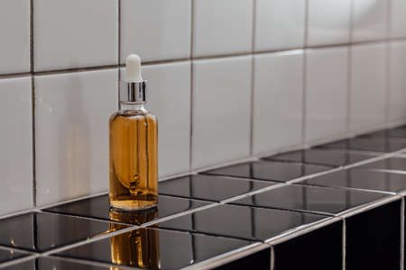 Natural Serum. Concept of cosmetic injection is hyaluronic acid, botulin, serum on the background of tiles in the bathroomの写真素材