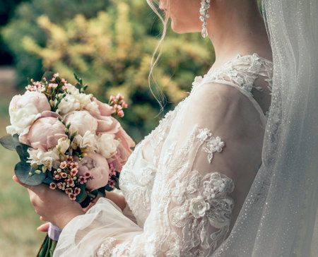 woman with bridal bouquet. eremony wedding day. hands with wedding rings.