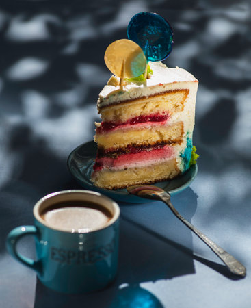 Plate with slice of tasty homemade raspberry cake. Colorful lollipop swirl on wooden stickの写真素材