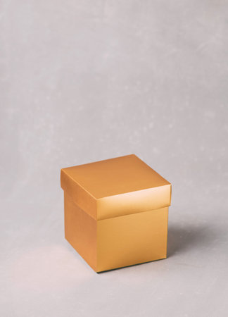 Golden gift box on a grey background. Copy space