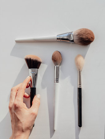 Woman holds brush for professional makeup. brushes set