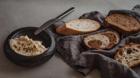 Fresh sliced bread with a bowl of butterの写真素材