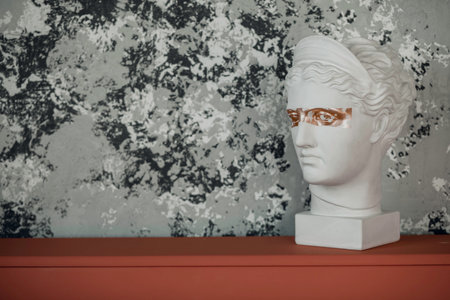Marble head of young woman, ancient Greek goddess bust i on grey background with space for text.の写真素材