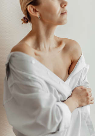 Woman in a white shirt. Body Care. Close Up Of collarbone . Spa, skin care and wellness. Light backgroundの写真素材