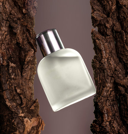 Blue perfume on tree bark on black background