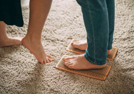 Barefoot woman standing nails on floor embracing man at home, caring wife and husband hugging, romantic couple kissing, love and feelings concept, male female legs feet togetherの写真素材