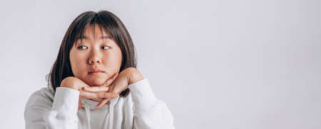 Beautiful young Asian girl thinking and looking upwards. Concept of content thinks about future on white background.の写真素材
