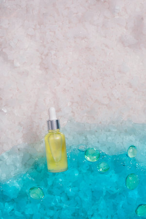 Cosmetic spa medical skincare, glass serum bottle with collagen on blue water background with mineral salts. Advertising of medical product for anti-aging care, moisturizingの写真素材