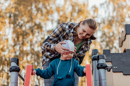 A boy, person with down syndrome walks in the park with his mother, spinning on the carouselの写真素材