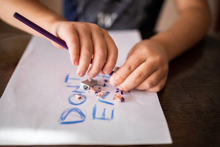 The child's hands with a pencil and sharpener over the paper with the inscription, do not enter