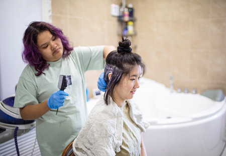 Teens dye their hair white, apply the dye to her hair at homeの写真素材