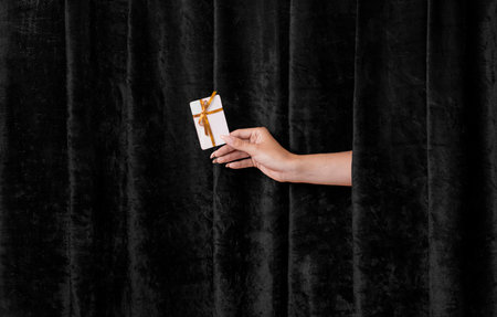 credit card in Golden ribbon. Hand Extends the Joy of Black Friday Shoppingの写真素材